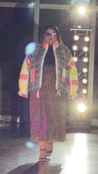 Model walking the runway wearing the Rainbow Puffer Jacket with a leopard print skirt.